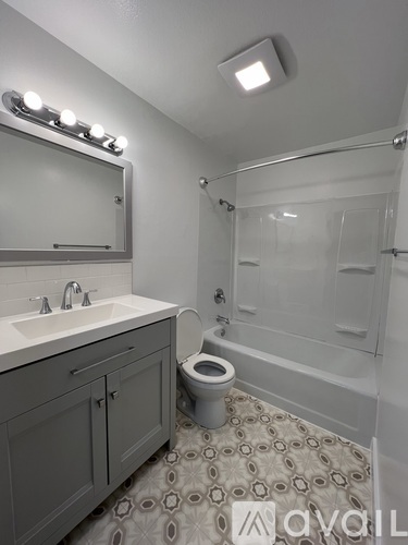 A bathroom with a toilet, sink, and mirror.