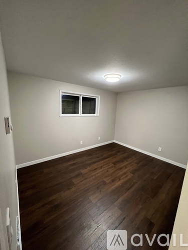 A room with wooden flooring and a window.