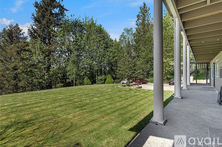 A house with a large lawn and trees in the background.