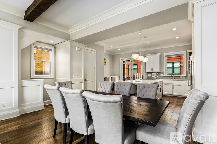 A dining room with a dark table and grey chairs.