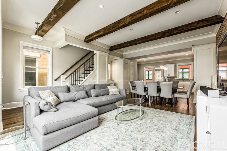 A living room with a grey couch and a glass coffee table.