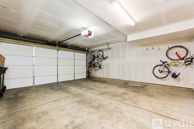 A garage with a white door and a bicycle hanging on the wall.