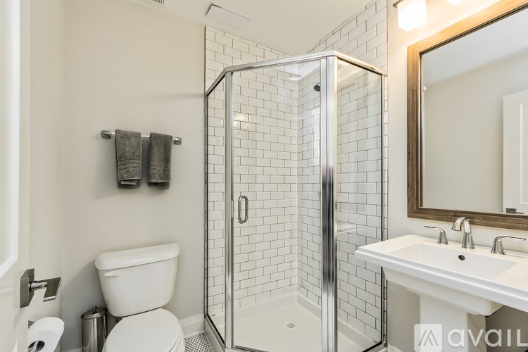 A bathroom with a toilet, sink, and shower.