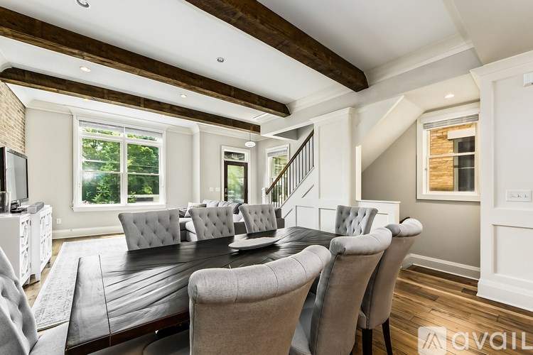 A dining room with a dark table and grey chairs.