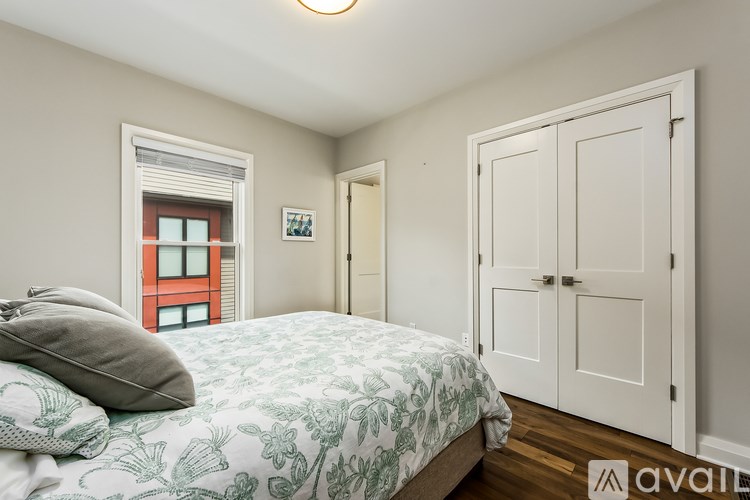 A bedroom with a bed, a window, and a door.