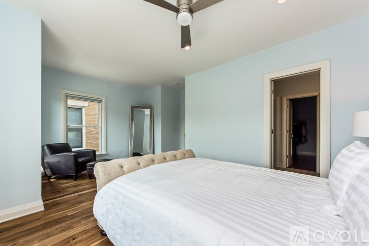 A bedroom with a large bed and a ceiling fan.