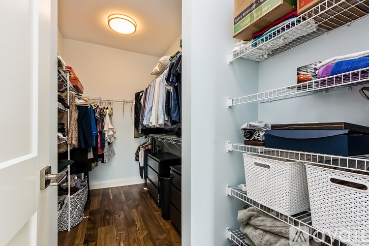 A walk-in closet with clothes and storage baskets.