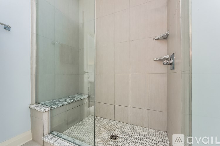 A glass shower stall with a bench inside.