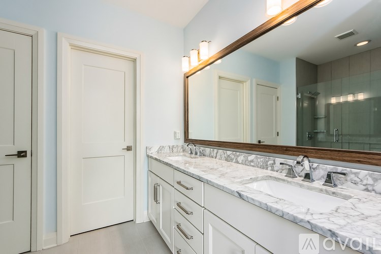 A bathroom with a marble countertop and a large mirror.