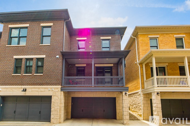 A modern two-story house with a balcony and garage.