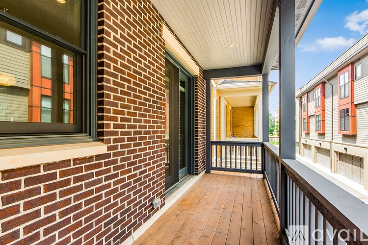 A balcony with a brick wall and a wooden floor.