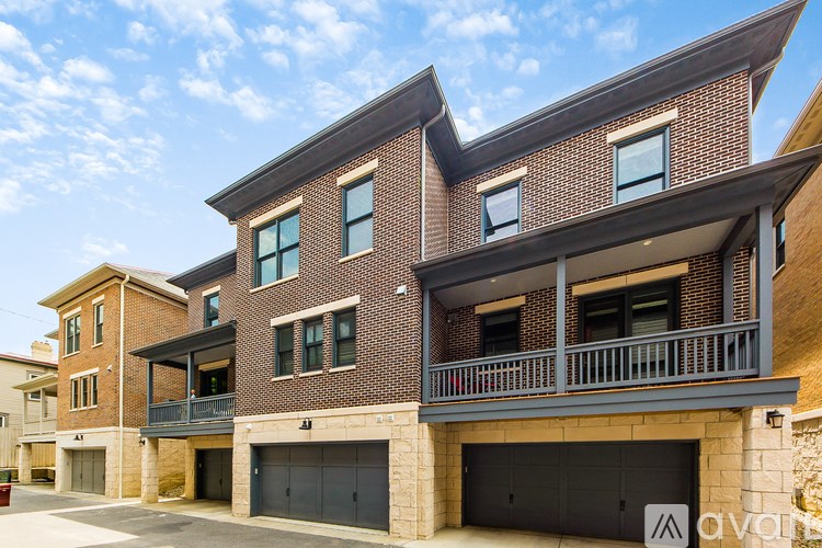 A modern two-story house with a balcony and garage doors.