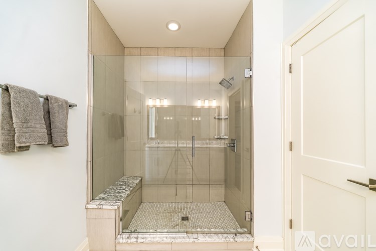 A bathroom with a walk-in shower and a towel rack on the wall.