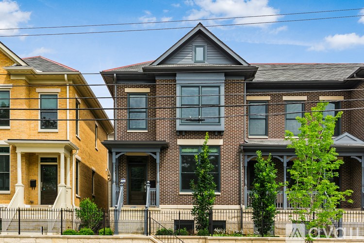 A row of houses with different colored front yards.