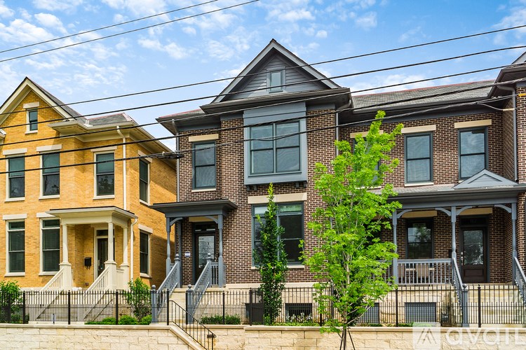Three houses with different facades stand side by side.