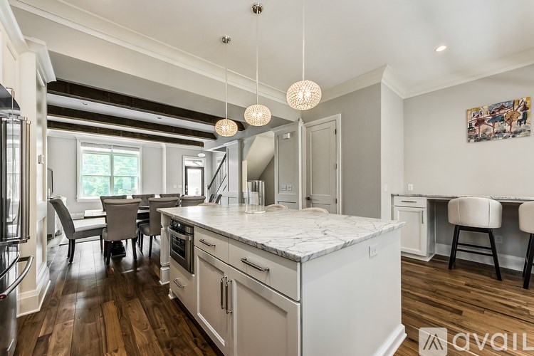 A kitchen with a white countertop and wooden floors.