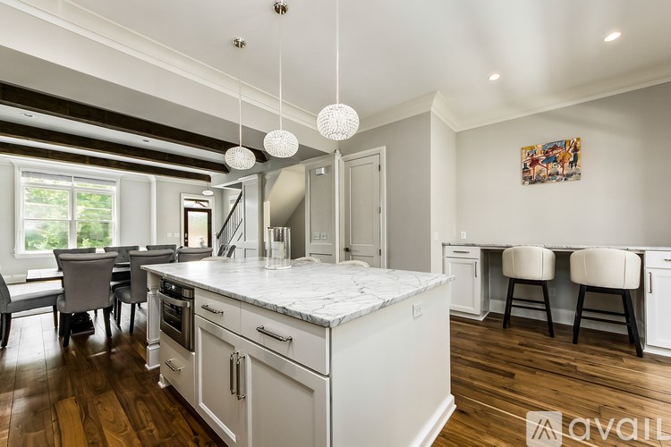 A kitchen with white cabinets and a marble countertop.