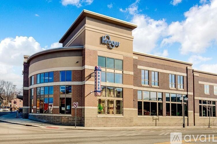 A Kroger store is shown with a blue sky and clouds in the background.