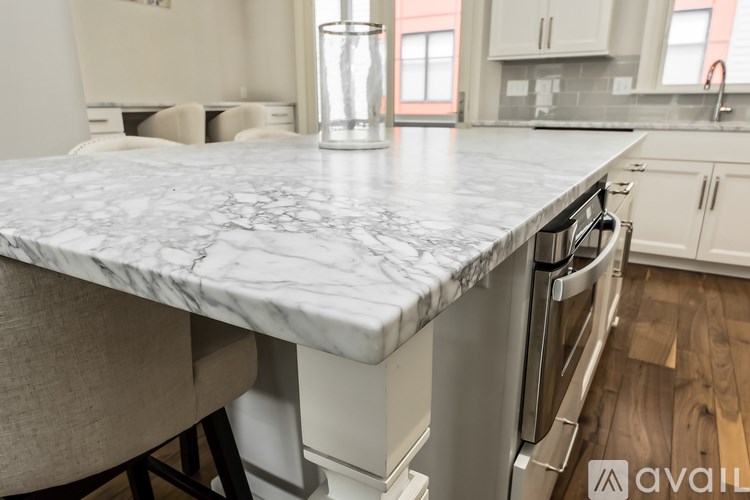 A kitchen with a marble countertop and a dishwasher.