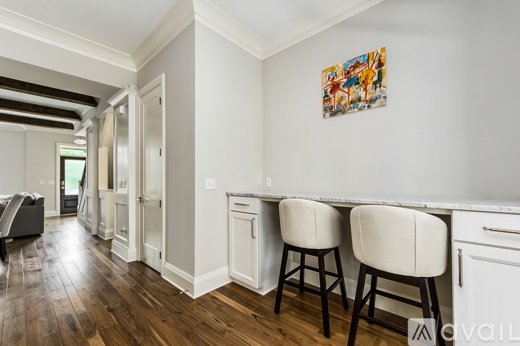 A kitchen with white cabinets and a painting on the wall.