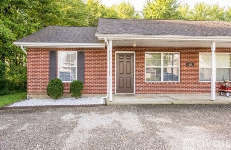A red brick house with a white door and windows.