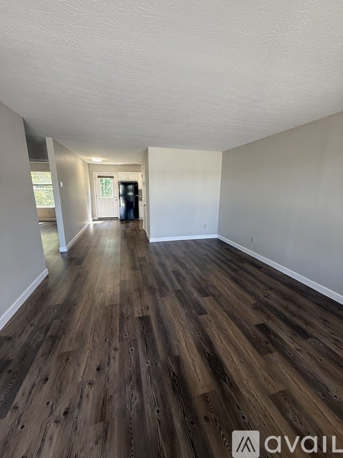 A room with wooden flooring and white walls.