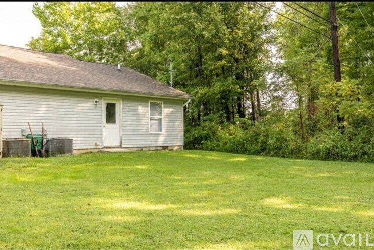 A house with a green lawn in front of it.
