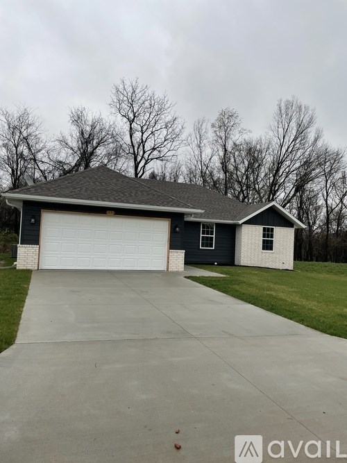 A house with a grey roof and a white garage door.
