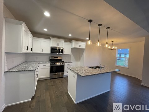 A kitchen with white cabinets and a granite countertop.
