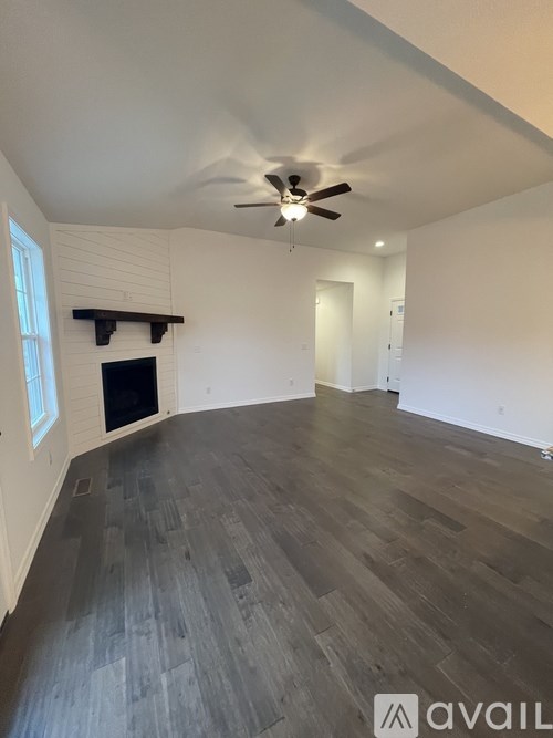 A room with a fireplace and a ceiling fan.