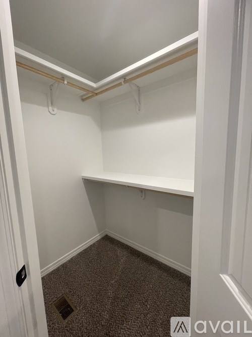 A small, empty room with a carpeted floor and white walls.