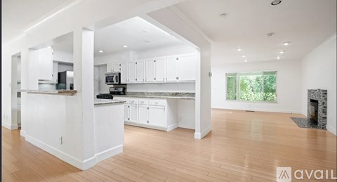 A spacious kitchen with white cabinets and a large island.
