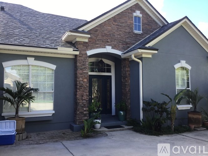 A house with a brick pillar and a window with blinds.