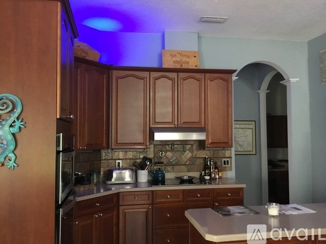 A kitchen with wooden cabinets and a tile backsplash.