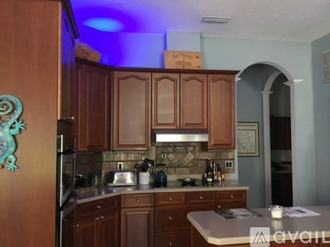 A kitchen with wooden cabinets and a tile backsplash.