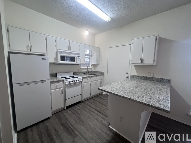 A kitchen with white appliances and cabinets.