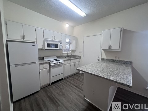 A kitchen with white appliances and cabinets.