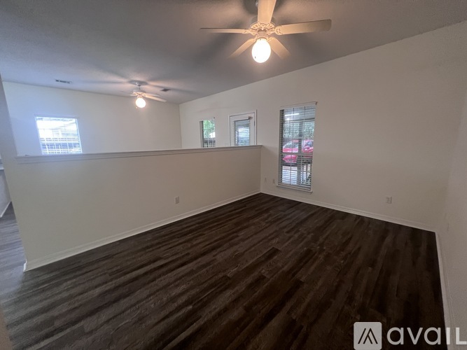 A room with wooden flooring and a ceiling fan.