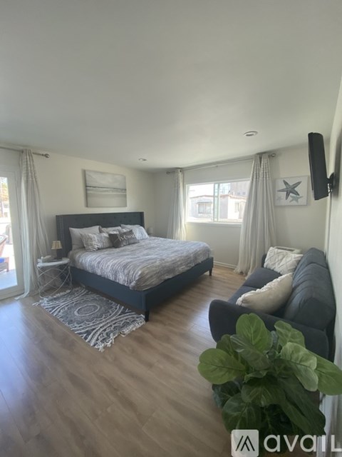 A bedroom with a large bed and a grey couch.
