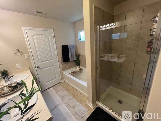 A bathroom with a white door and a glass shower stall.