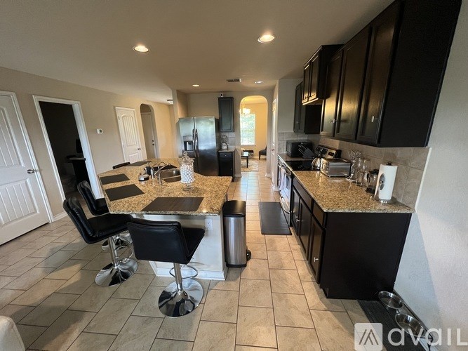 A kitchen with black cabinets and a granite countertop.