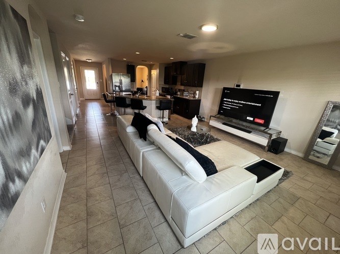 A modern living room with a large white sofa and a television.