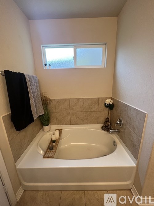 A bathroom with a tub and a window.