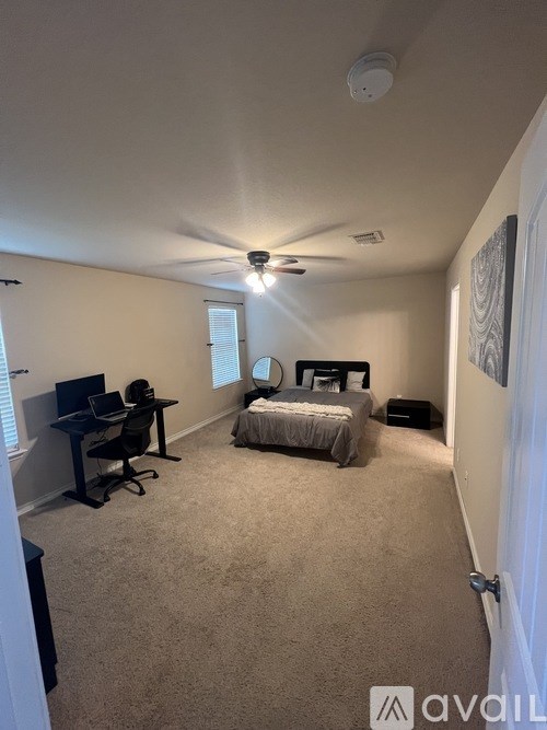 A bedroom with a bed, desk, and chair.