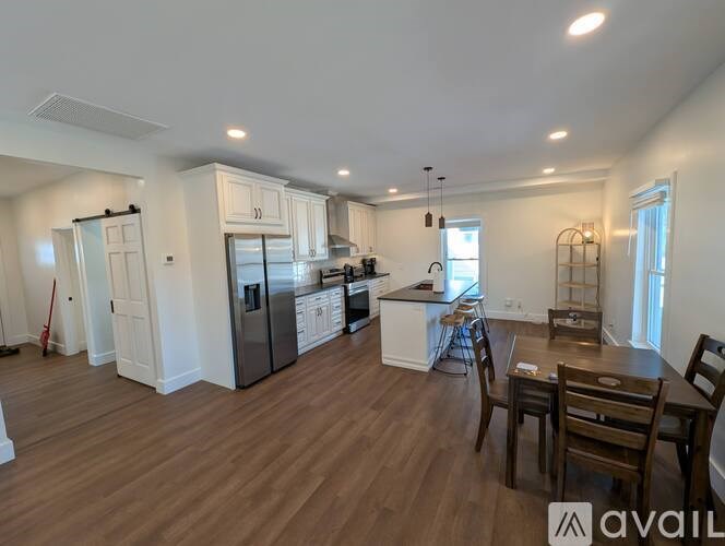A kitchen with a dining table and chairs in the foreground.