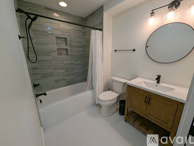 A bathroom with a white toilet, a white sink, a white bathtub, and a white shower curtain.