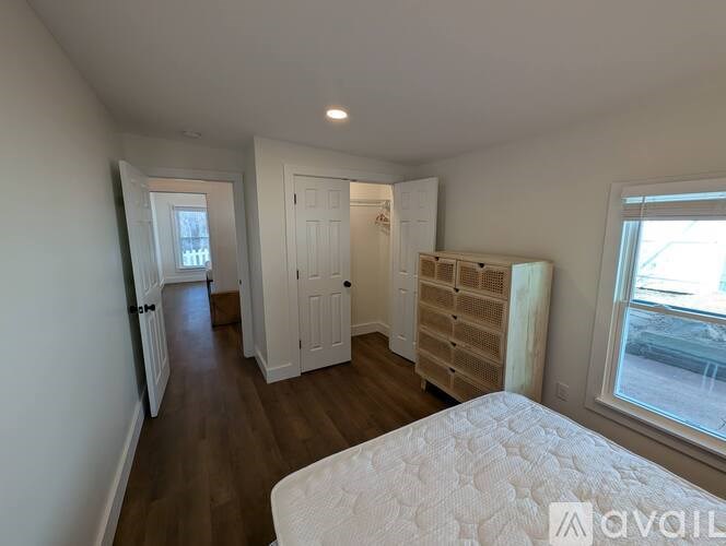 A bedroom with a large bed and a window overlooking a street.