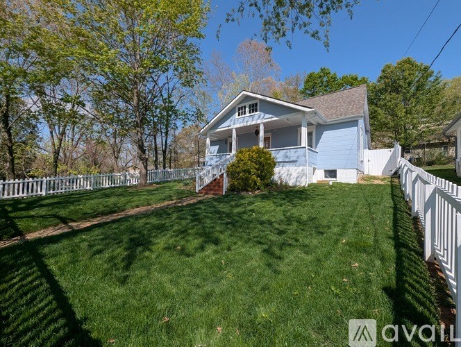 A house with a white fence and green lawn.