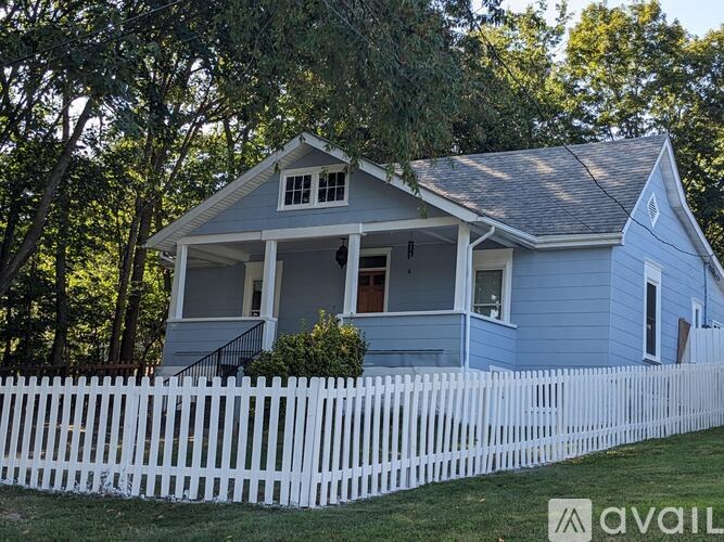 A blue house with a white picket fence in front.
