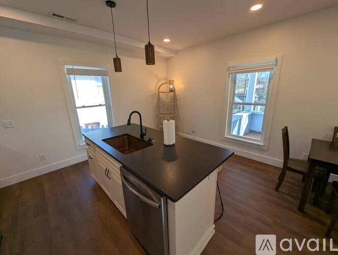 A kitchen with a black countertop and stainless steel appliances.